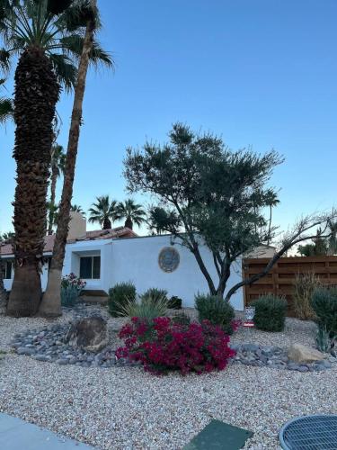 a house with palm trees and flowers in a yard at Casa de Cantera in Palm Springs