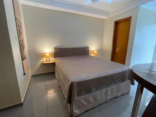 a bedroom with a bed and two lamps on two tables at Apartment with the best location in MOC in Montes Claros