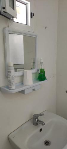 a bathroom sink with a mirror on a shelf above it at Alojamiento Abdel in Larache