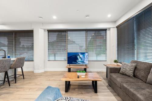 a living room with a couch and a table at Beach Suites in Parksville