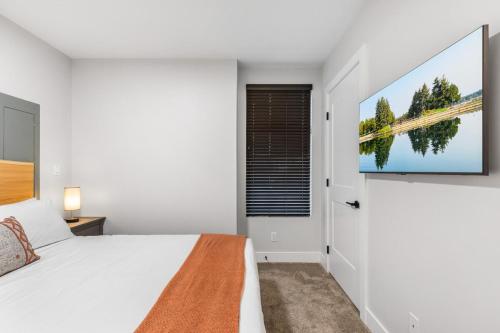 a bedroom with a white bed and a window at Beach Suites in Parksville