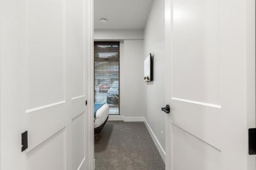 a hallway with white doors and a window at Beach Suites in Parksville