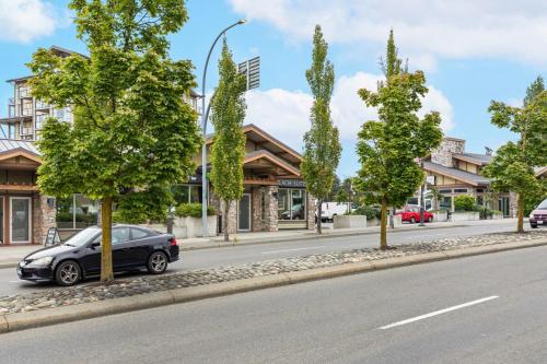 a car parked on the side of a street with trees at Beach Suites in Parksville
