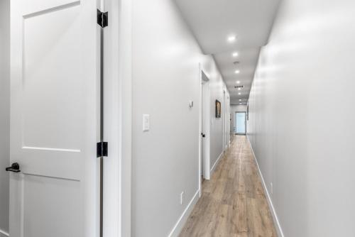 a hallway with white doors and wooden floors at Beach Suites in Parksville