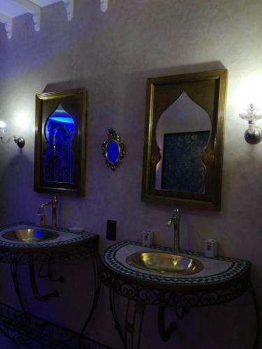 a bathroom with two sinks and two mirrors at Eden Suites 