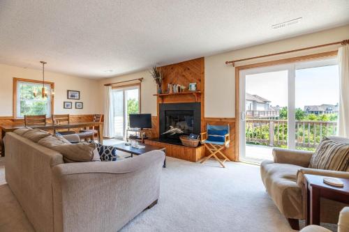 a living room with a couch and a fireplace at Persimmon in Duck