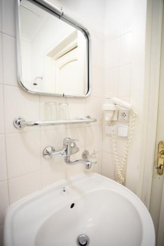 a bathroom with a white sink and a mirror at Hotel Ester in Karlovy Vary