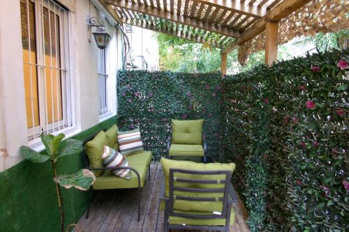 a patio with chairs and a pergola at Stylish Garden Apt 2 Min Beach in Tel Aviv