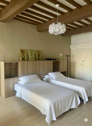 two white beds in a room with a ceiling at Agorà in Umbertide
