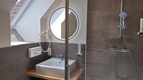 a bathroom with a sink and a mirror at Hotel Garni Landhaus Florian in Bad Blumau