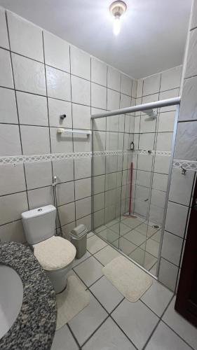 a bathroom with a shower and a toilet and a sink at Casa Aconchegante in Natal