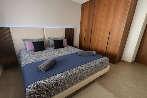 a bedroom with a bed with purple and black pillows at Appartement S1 Luxueux in Tunis
