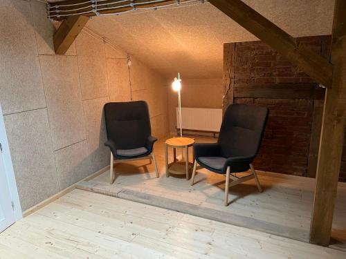 two chairs and a table in a room at Brīvības osta in Aizpute