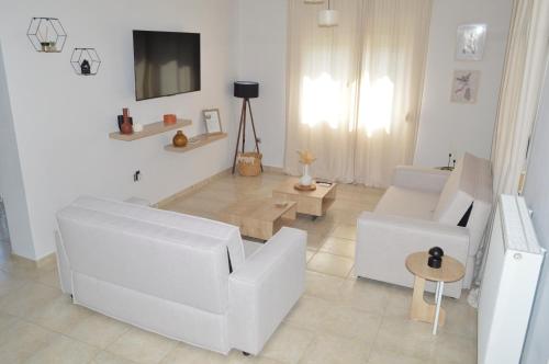 a living room with two white couches and a tv at "LaGo Village House" Family & Group Retreat near Meteora in Kalabaka