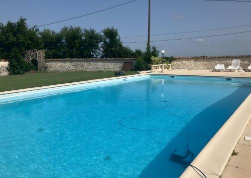 a large swimming pool with blue water at Chez Bilhouet in Segonzac