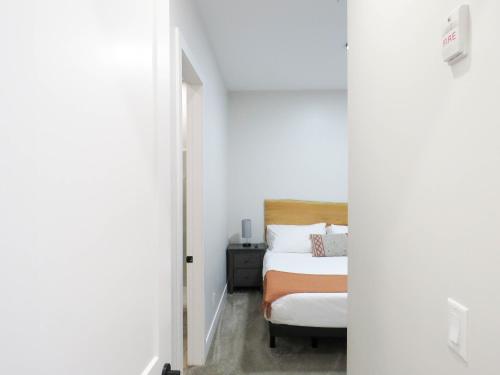 a small bedroom with a bed and a chair at Beach Suites in Parksville