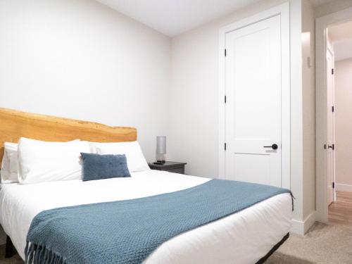 a bedroom with a large bed with a blue blanket at Beach Suites in Parksville