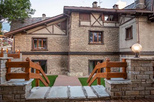 two wooden chairs sitting in front of a building at Hotel K2 in Sauze dʼOulx
