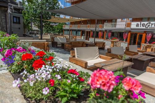 a patio with chairs and flowers in front of a building at Hotel K2 in Sauze dʼOulx