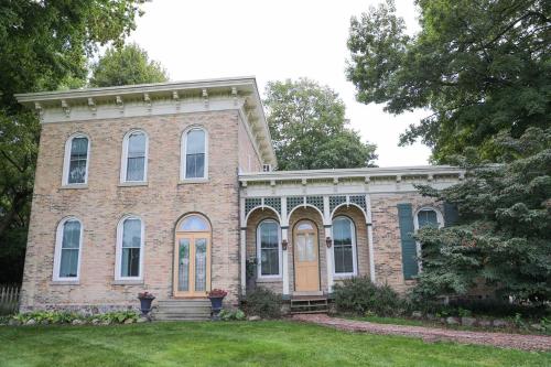 an old brick house with orange doors and a yard at Bed & Breakfast private room near Amish Country in Elkhart
