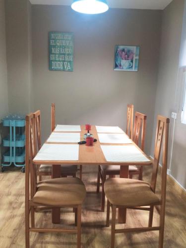 a dining room table with chairs and a wooden table at A Fontana de Luxo Apartamentos in Portomarin