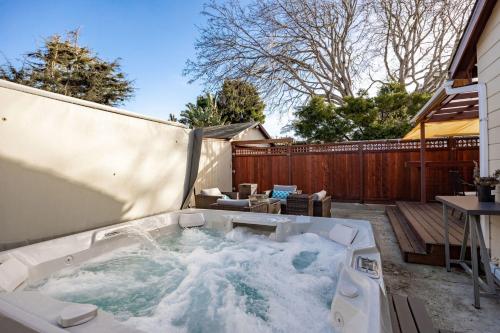 ein Whirlpool im Hinterhof eines Hauses in der Unterkunft Charming Garden Cottage- steps to historic Old Town Half Moon Bay in Half Moon Bay