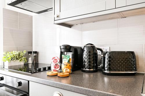 a kitchen counter top with a coffee maker on it at Ealing Broadway Apartment - 2-Min To Tube & Shops - WIFI - Netflix in Ealing