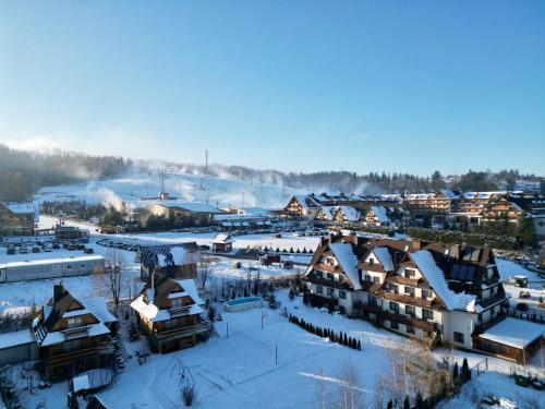 a small town covered in snow with buildings at Domki w Białce pod Basenami, 50 m od term i wyciągów in Białka Tatrzanska