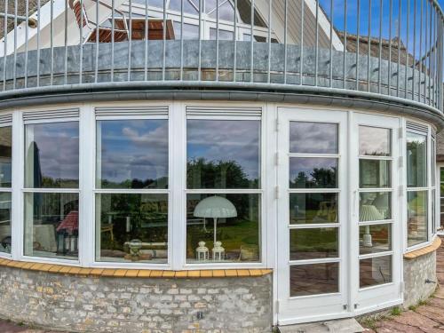 a house with large windows and a balcony at Holiday Home Herlek - 450m from the sea by Interhome in Åkirkeby