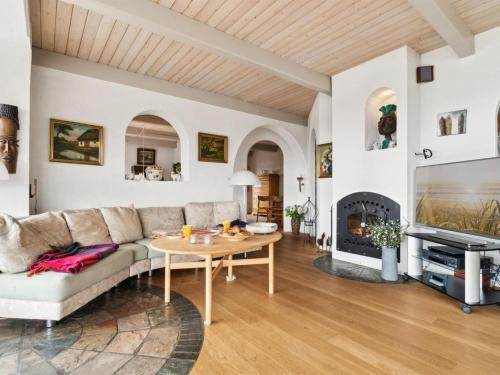 a living room with a couch and a table at Holiday Home Herlek - 450m from the sea by Interhome in Åkirkeby