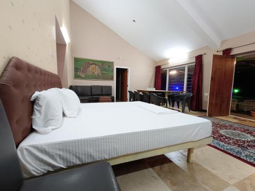 a bedroom with a bed and a living room at Mountain View Private Villa in Ooty