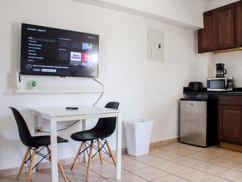 a kitchen with a table and two chairs and a tv at Boulevard Park IV 301 in Mayaguez