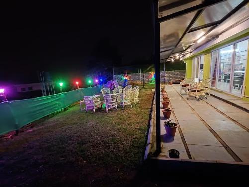 a group of chairs sitting on a patio at night at Mountain View Private Villa in Ooty