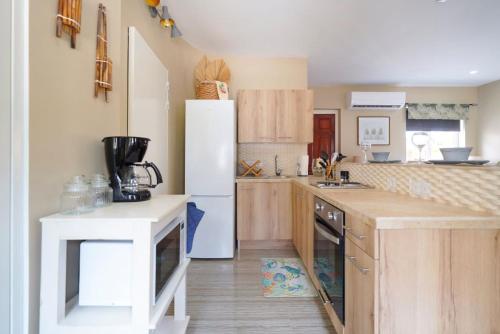 Una cocina con refrigerador blanco y gabinetes de madera. en Tropical Tranquility, en Grote Berg