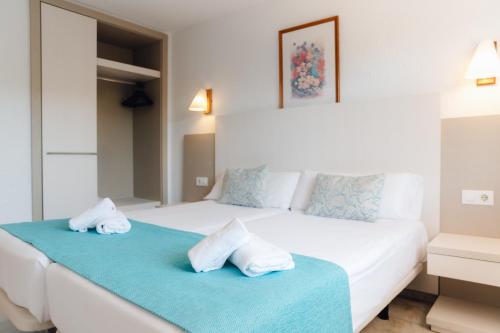 Un dormitorio con dos camas con toallas encima. en Apartamentos Moon Dreams Los Lentiscos, en Cala en Blanes