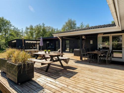 a wooden deck with a picnic table and tables at Holiday Home Gudni - 200m to the inlet by Interhome in Fur