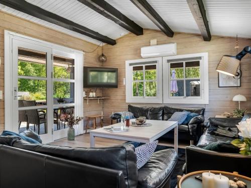 a living room with leather furniture and a table at Holiday Home Gudni - 200m to the inlet by Interhome in Fur