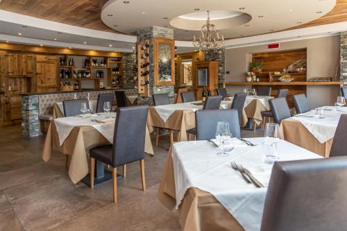 a restaurant with tables and chairs and a chandelier at Hotel K2 in Sauze dʼOulx