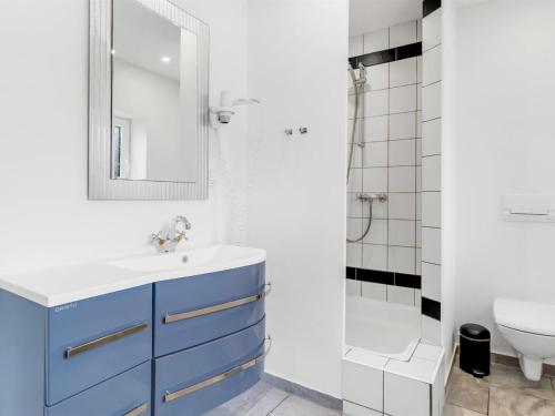 a bathroom with a blue sink and a shower at Holiday Home Aliza - 14km from the sea by Interhome in Bredebro