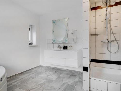 a white bathroom with a sink and a mirror at Holiday Home Aliza - 14km from the sea by Interhome in Bredebro