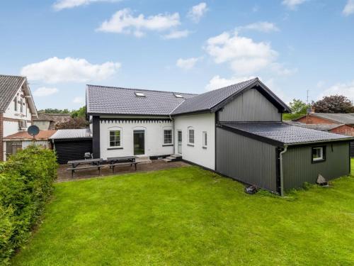 a large yard with a white and green house at Holiday Home Aliza - 14km from the sea by Interhome in Bredebro