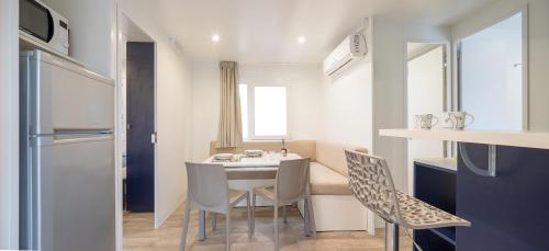 a small kitchen and dining room with a table and chairs at Camping Village Cavallino in Cavallino-Treporti