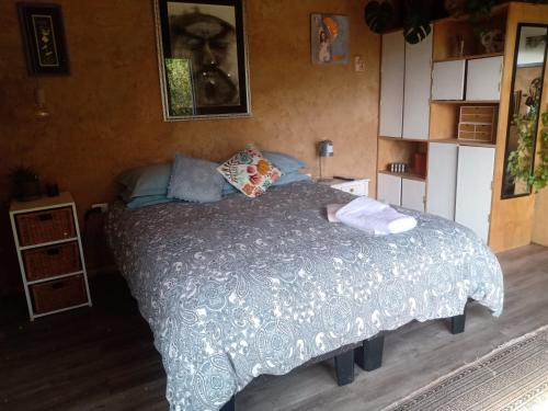a bedroom with a bed with a gray comforter at Refugio en adobe con terraza y vista in Concepción