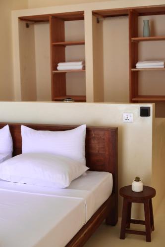 a bedroom with a bed and a table and shelves at La Brisa Mirissa - Boutique hotel in Mirissa