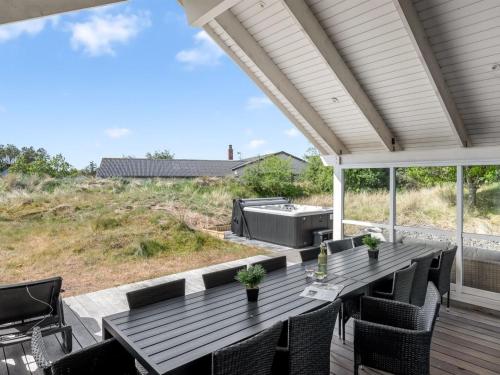 a patio with a table and chairs and a grill at Holiday Home Jeldrik - 1-5km from the sea by Interhome in Blåvand