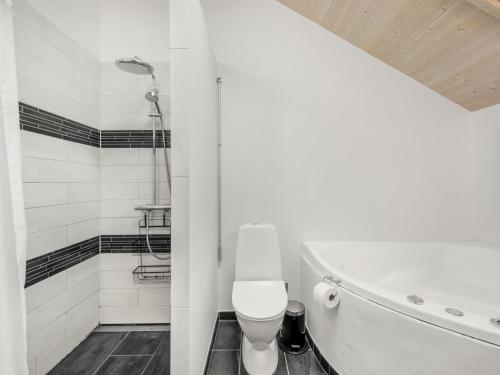 a bathroom with a toilet and a bath tub at Holiday Home Jeldrik - 1-5km from the sea by Interhome in Blåvand
