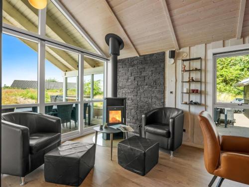 a living room with leather chairs and a fireplace at Holiday Home Jeldrik - 1-5km from the sea by Interhome in Blåvand