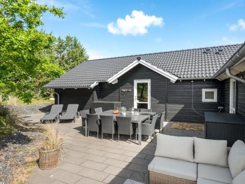 a patio with a table and chairs in front of a house at Holiday Home Jeldrik - 1-5km from the sea by Interhome in Blåvand
