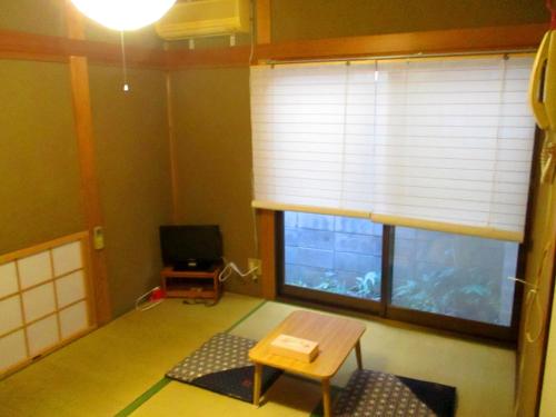 a living room with a window and a table and a tv at Uji - House - Vacation STAY 9753 in Uji