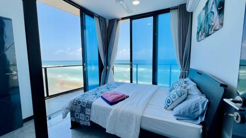 a bedroom with a bed with a view of the ocean at Beachfront Colombo 03 Bed Apartment in Colombo